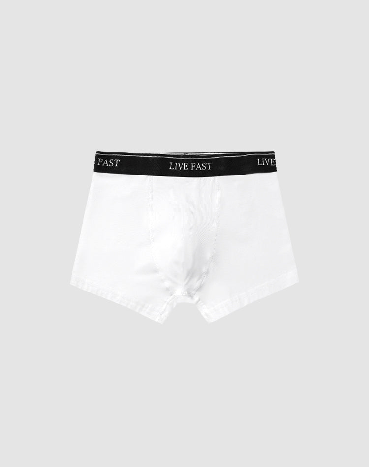 A pair of Live Fast Trunks (2 Pack) by LIVE FAST DIE YOUNG in white cotton features a black elastic waistband with LIVE FAST in white, set against a plain light gray background.