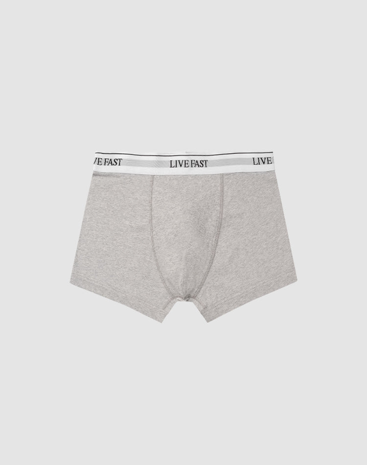 LIVE FAST DIE YOUNGs Live Fast Trunks (2 Pack) feature gray mens boxer briefs in soft cotton with a LIVE FAST black elastic waistband. Care instructions for easy maintenance included; shown on a light gray background.