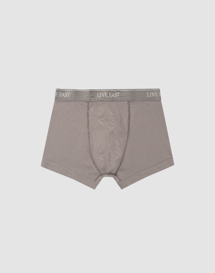 LIVE FAST DIE YOUNG’s Live Fast Trunks (2 Pack) feature soft gray cotton, a visible front pouch, and an elastic waistband with repeated LIVE FAST branding. Displayed flat on a light gray background. Care instructions included.