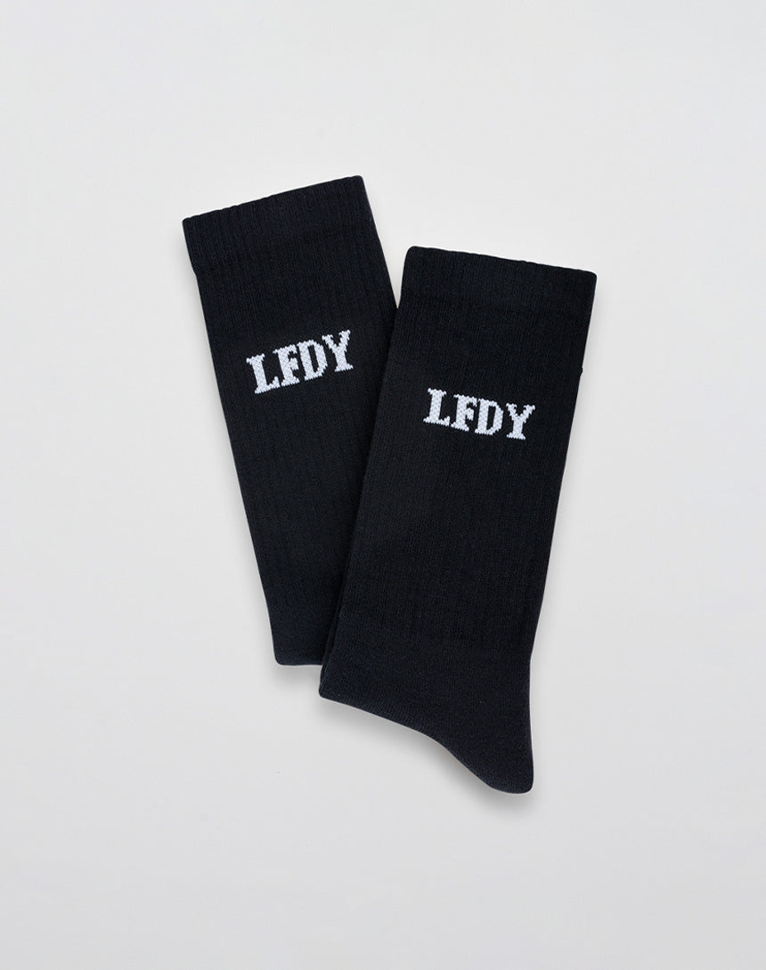 LIVE FAST DIE YOUNGs LFDY Logo Socks (2 Pack): Black socks crafted from a soft Baumwolle-Polyamid-Elastan blend, each featuring white embroidered LFDY lettering, shown flat on a light gray background.