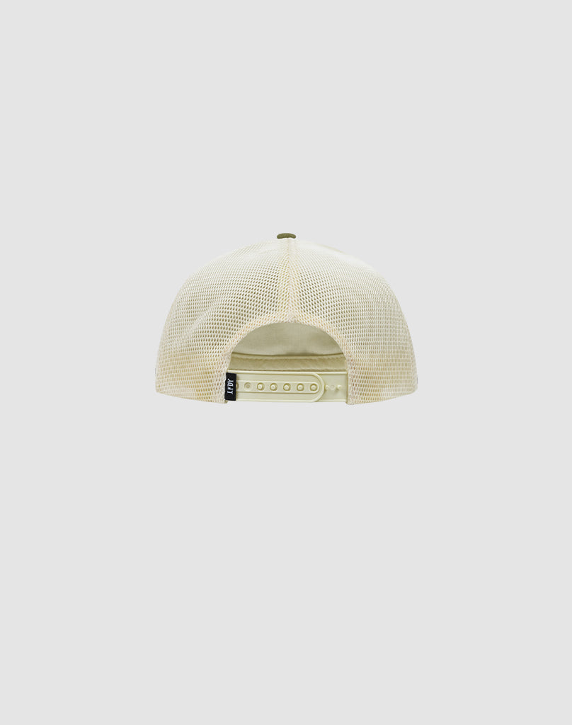 The LFDY Patched Trucker by LIVE FAST DIE YOUNG is shown from the back in beige mesh, with an adjustable Snapverschluss and a small black Logo-Stick tag on the left side. Background is plain light gray.