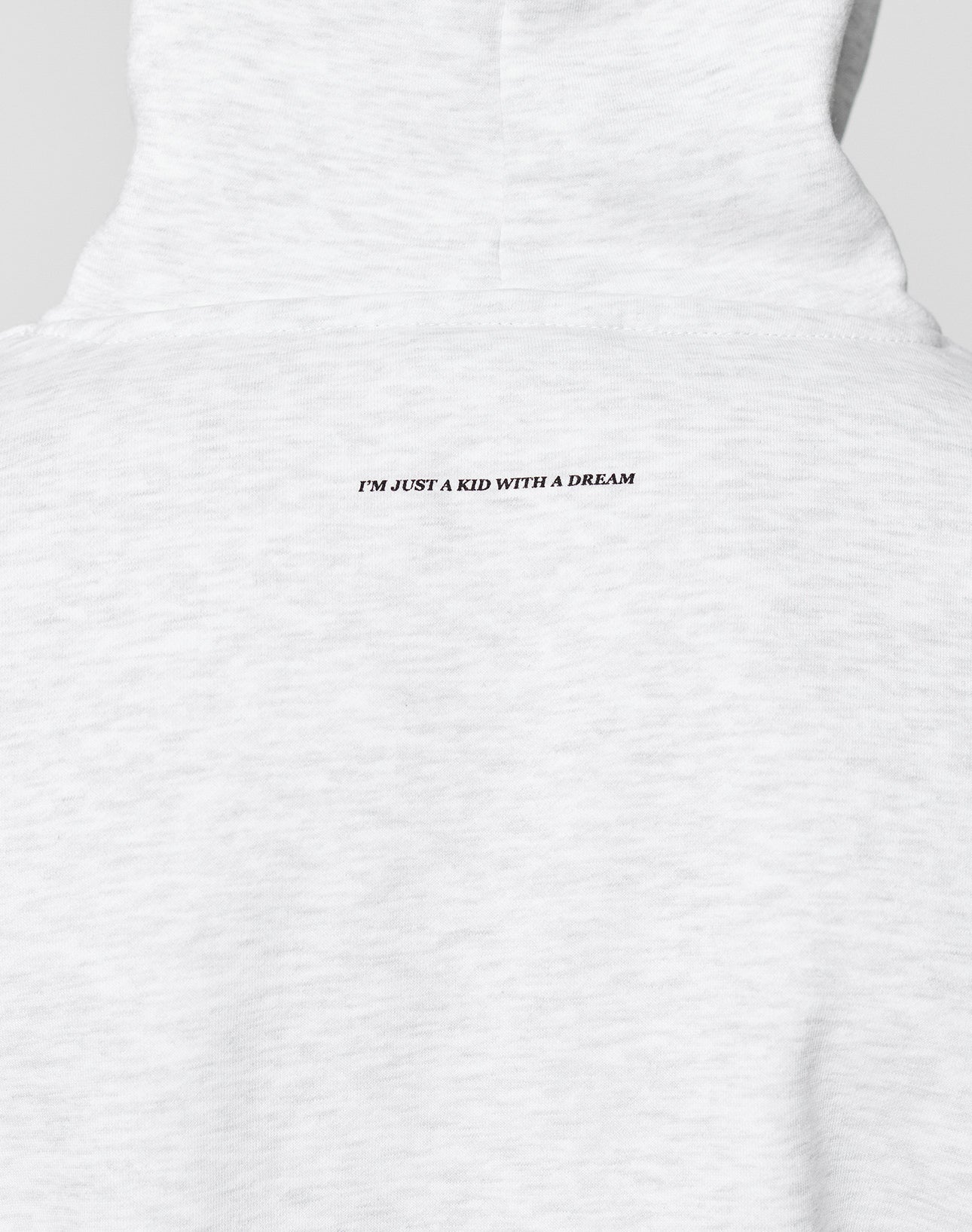 A close-up of the backprint on the Live Fast College Hooded by LIVE FAST DIE YOUNG in light gray, showing small black IM JUST A KID WITH A DREAM text near the neckline.