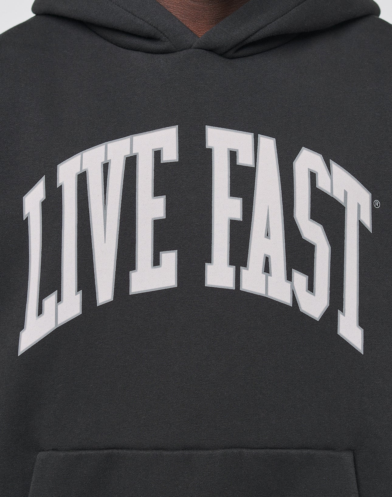 A close-up of the Live Fast College Hooded by LIVE FAST DIE YOUNG, an oversized black hoodie with LIVE FAST boldly printed in large white letters across the chest.