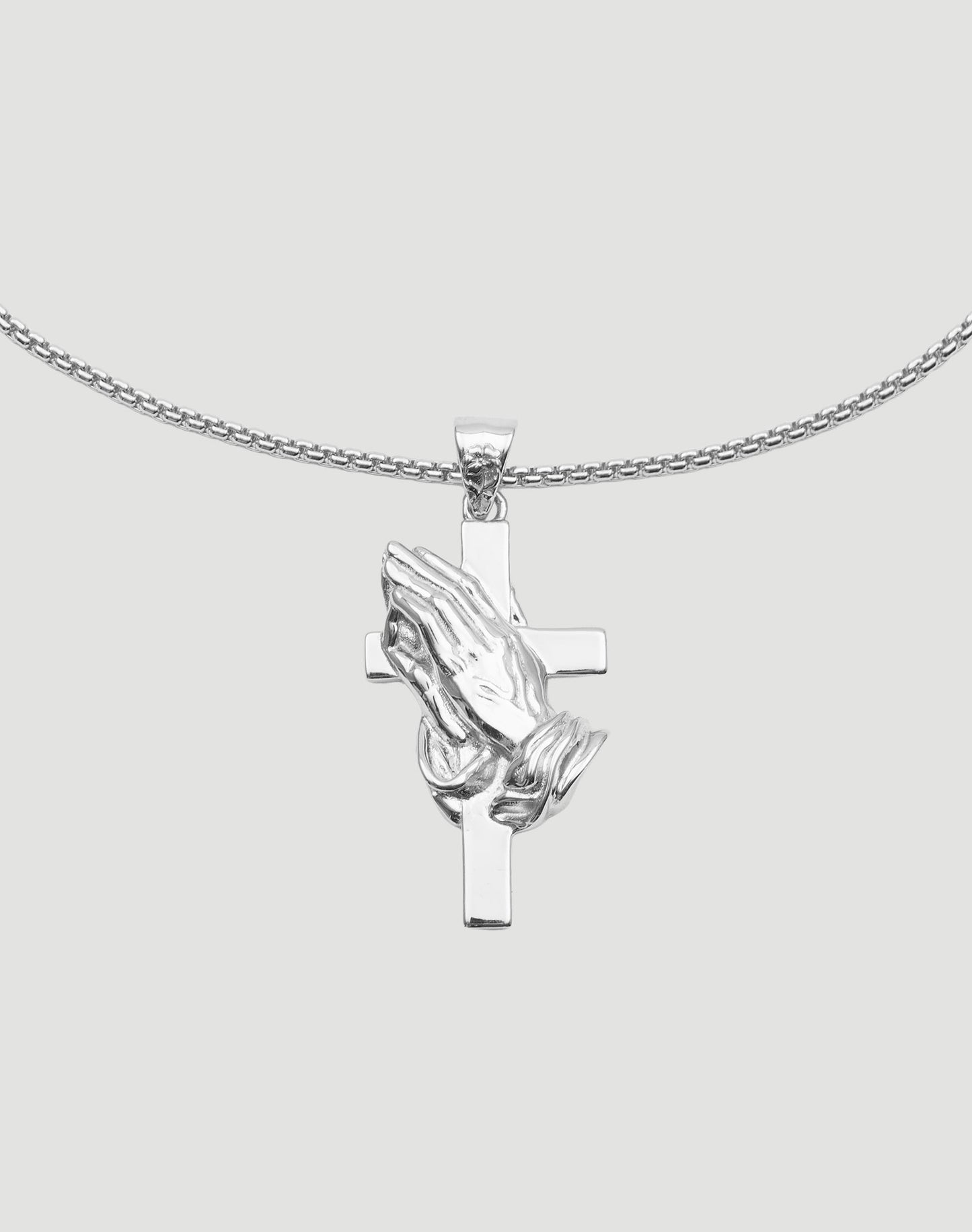 Die LFDY Praying Chain von LIVE FAST DIE YOUNG ist eine 52 cm lange, größenverstellbare Sterlingsilberkette mit Anhänger aus zwei betenden Händen über einem Kreuz – präsentiert vor schlichtem, hellgrauem Hintergrund.