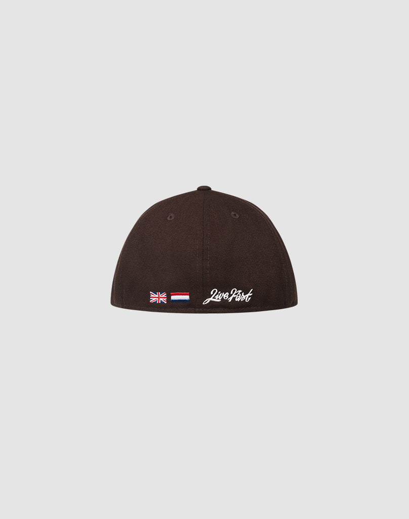 A black LFDY X NEW ERA 59FIFTY LOW PROFILE fitted cap by LIVE FAST DIE YOUNG, shown from the back with small embroidered flags and white Love Posit text, on a plain light gray background.