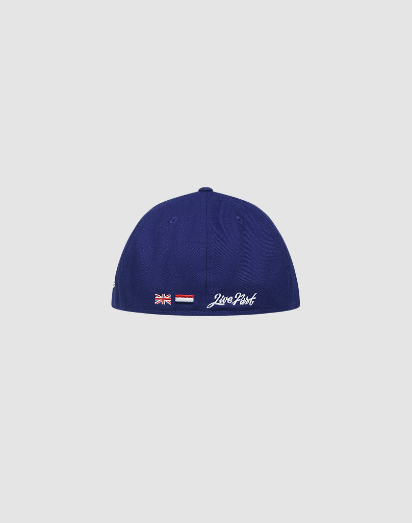 A blue LFDY x NEW ERA 59FIFTY LOW PROFILE fitted cap by LIVE FAST DIE YOUNG, shown from the back with embroidered flags and white Loro Piana script on a plain light gray background.