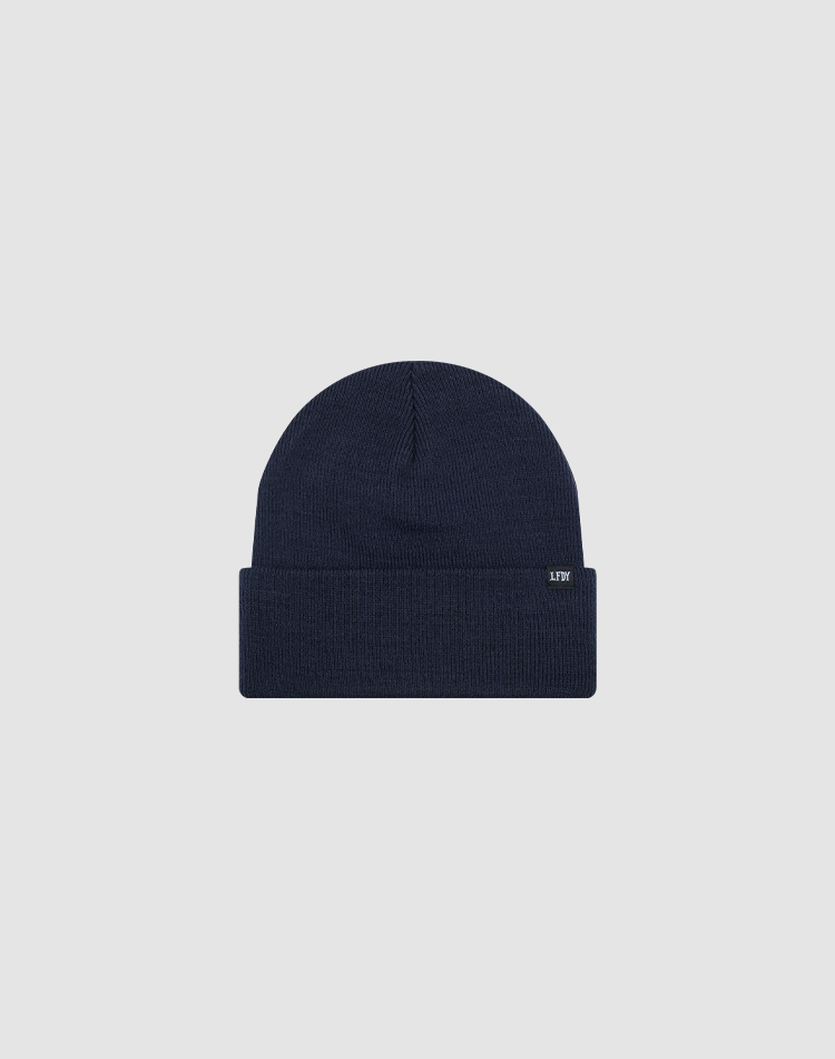 The LIVE FAST DIE YOUNG Basic Beanie in navy blue features a folded brim and a small rectangular flag label on the cuff, shown in one size against a plain light gray background.