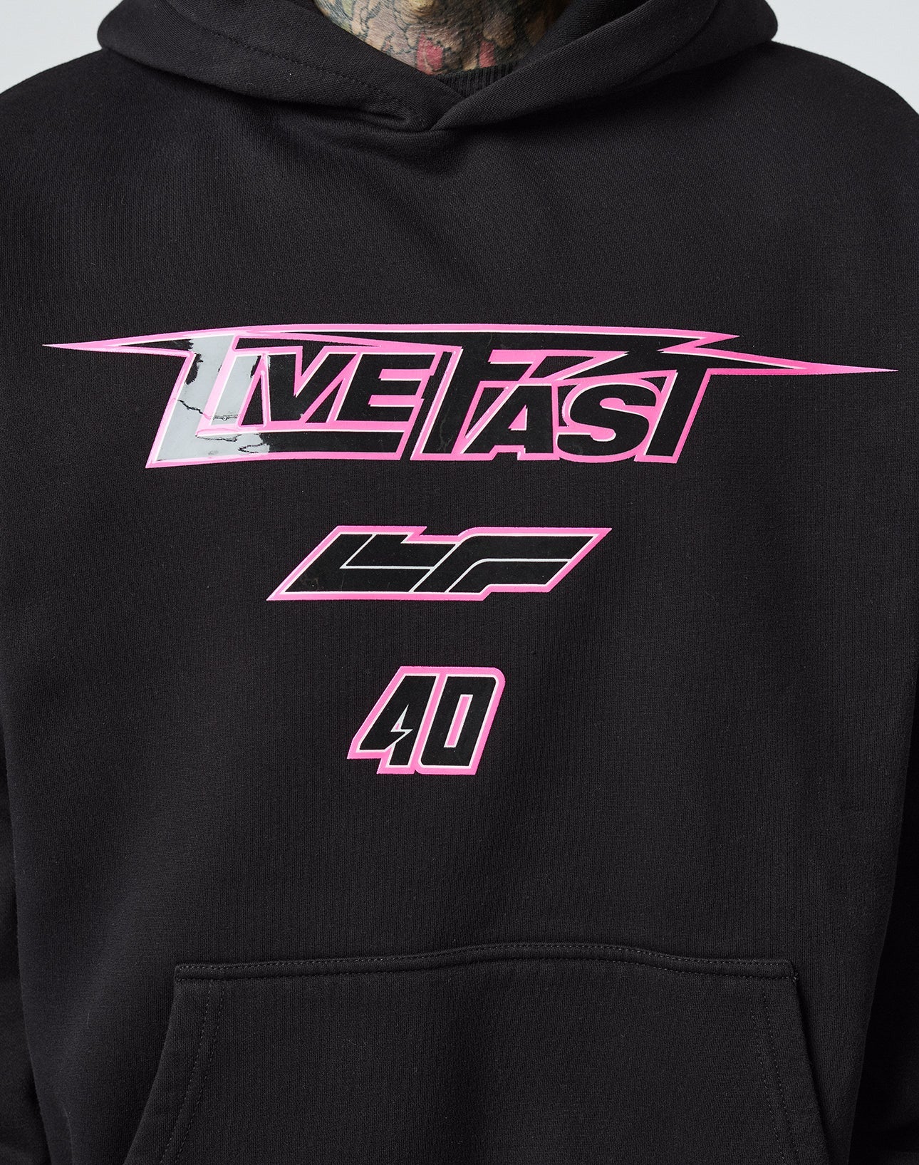 A close-up of the LFDY Triple Racing Hooded by LIVE FAST DIE YOUNG in black Baumwolle, Oversize Fit, with “LIVE FAST” in bold pink letters, “LF” below, and “40” at the bottom in a striking multilogo pink and white design.