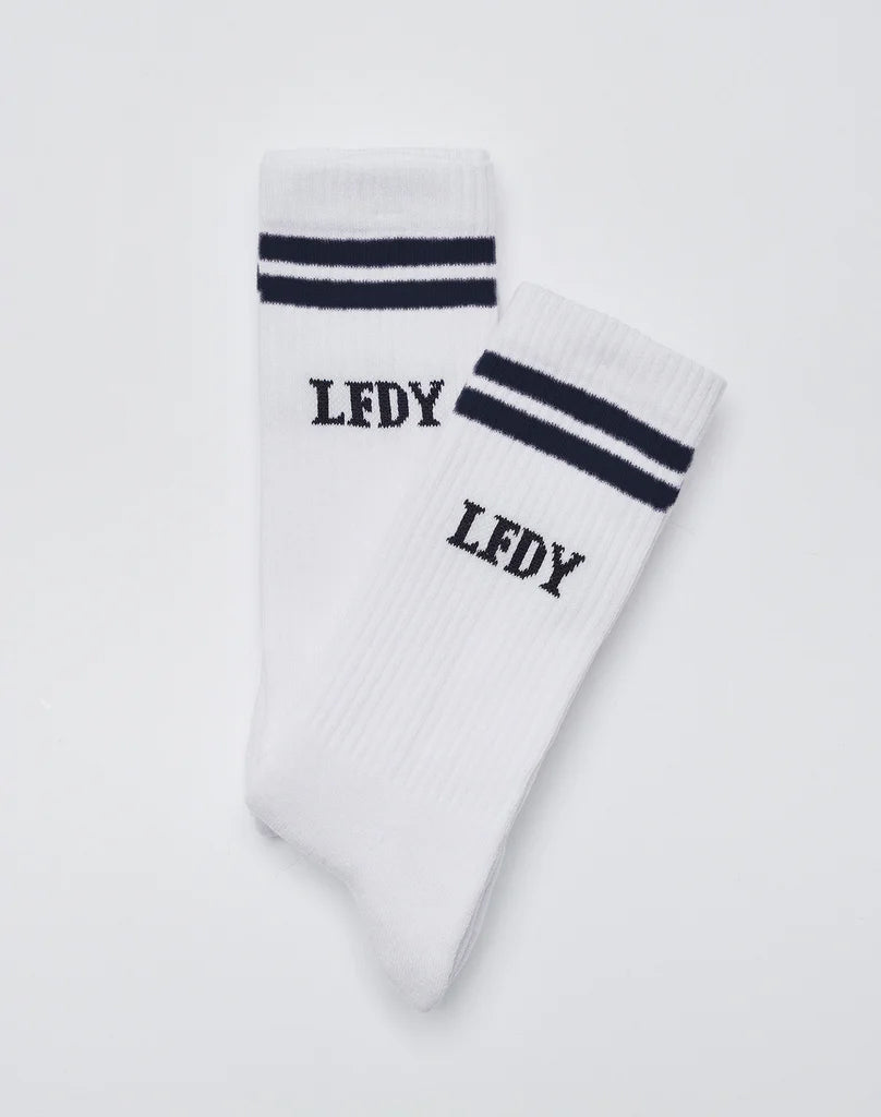 A pair of white Basic Socks (2 Pack) by LIVE FAST DIE YOUNG featuring two black stripes near the top and LFDY embroidered below. Made from a soft cotton blend, displayed on a plain, light background.