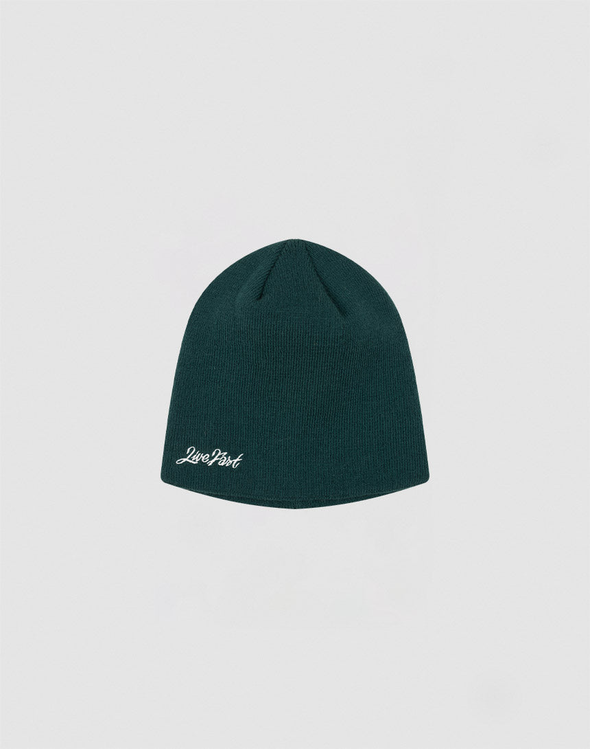 A dark green Script Beanie by LIVE FAST DIE YOUNG, featuring a small white Just Past logo on the front, displayed against a plain light gray background.