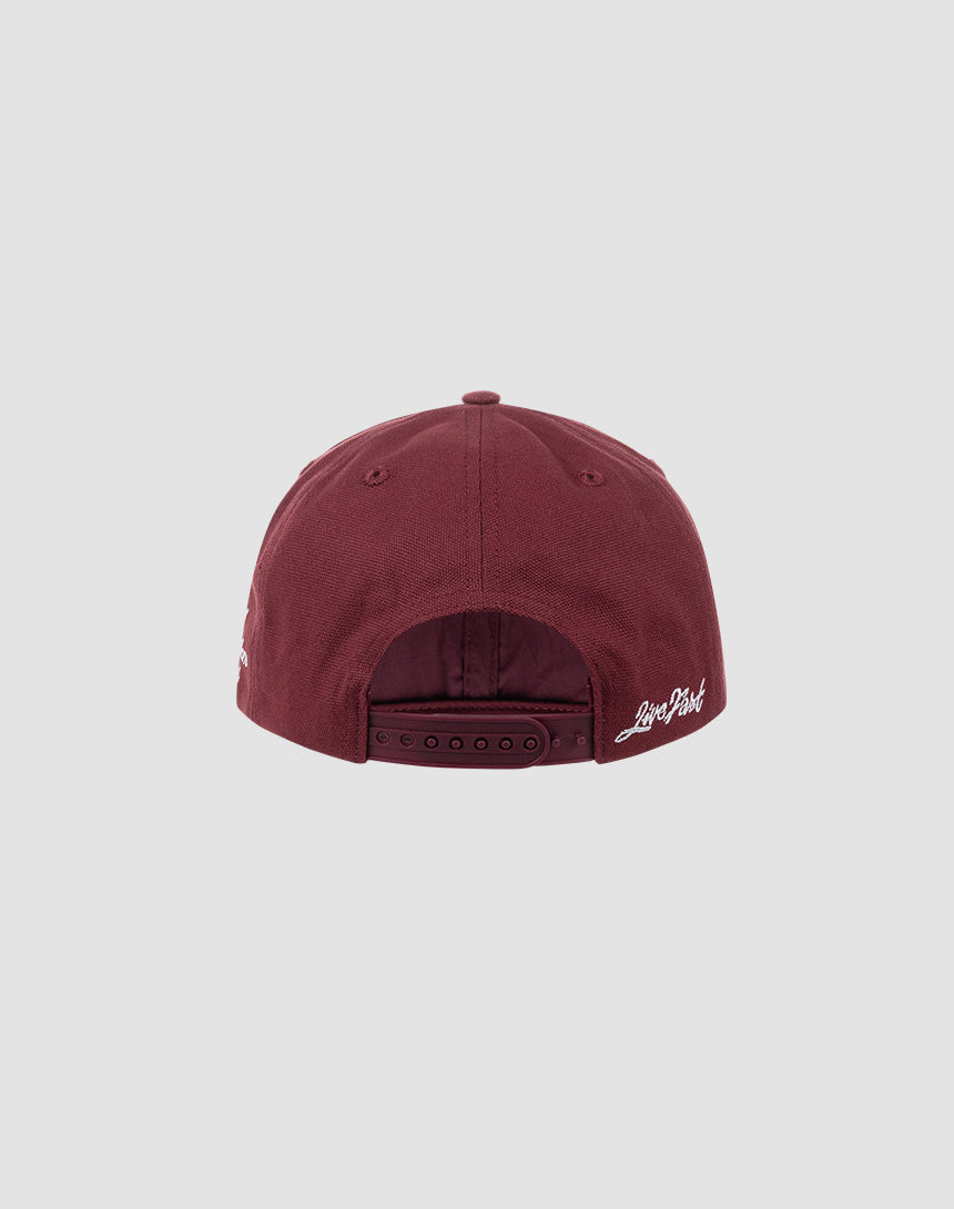 The LF Snapback by LIVE FAST DIE YOUNG is a maroon cotton baseball cap, shown from the back with an adjustable snap closure and white LIVE FAST DIE YOUNG logo on the right strap, set against a plain light gray background.