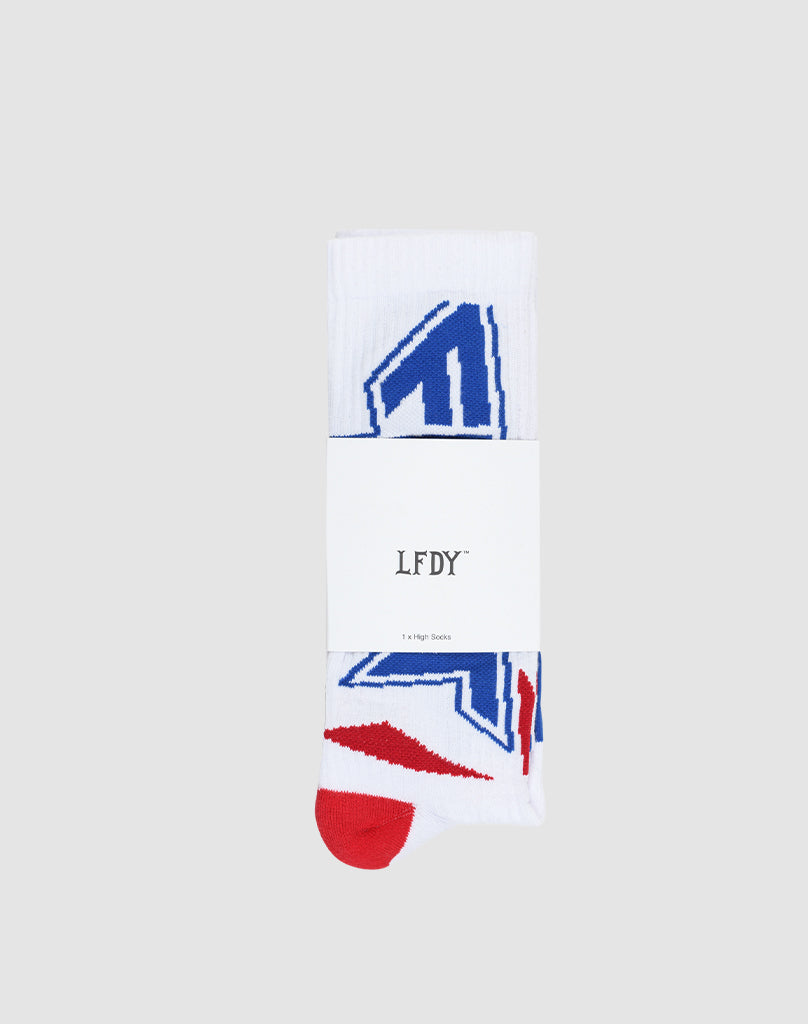 A single pair of Live Fast Cross Socks by LIVE FAST DIE YOUNG, crafted from soft cotton with blue and red graphics, folded and wrapped in a white LFDY label on a plain light gray background.