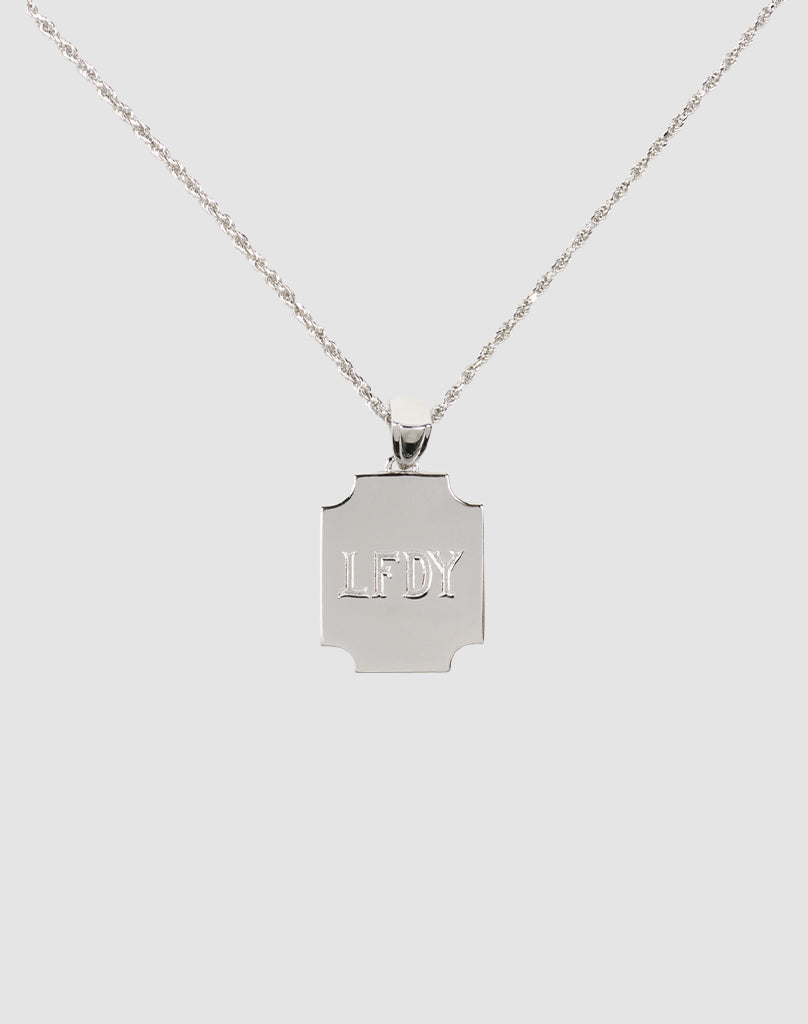 The LFDY Monaco Boys Plate Chain by LIVE FAST DIE YOUNG features a silver necklace with a rectangular pendant engraved with LFDY, displayed on a plain light gray background.