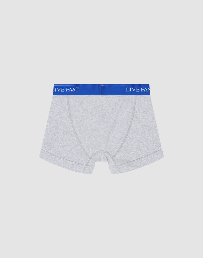 A pair of light gray Live Fast Trunks by LIVE FAST DIE YOUNG in Regular Fit, made of soft cotton with a blue elastic waistband reading LIVE FAST in white, shown on a plain white background.