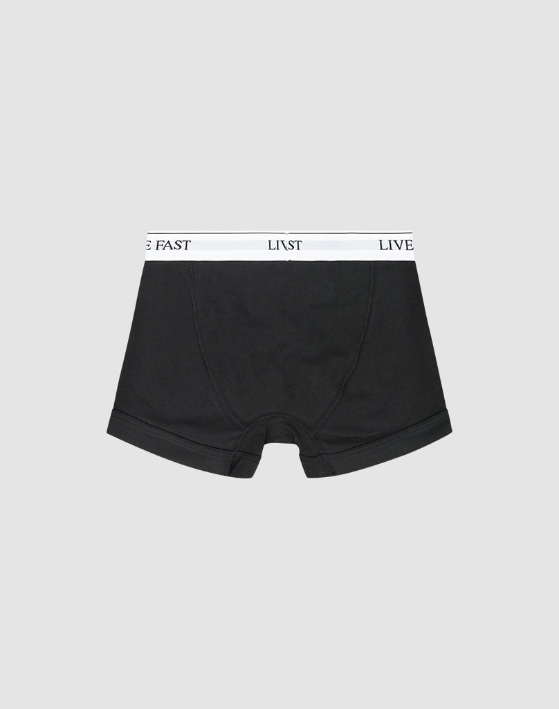 LIVE FAST DIE YOUNG Live Fast Trunks (2 Pack): Black regular-fit boxer briefs with a white waistband featuring LIVE FAST in black text, shown on a light gray background.