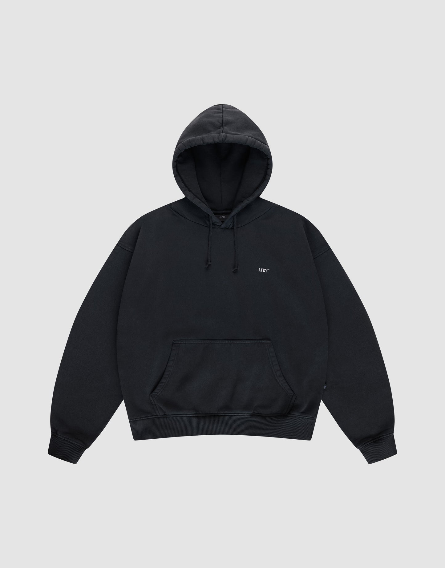The Live Fast Vegas Hooded by LIVE FAST DIE YOUNG is a plain black oversized hoodie with a hood, front pocket, drawstrings, and small white text on the left chest, shown on a light gray background.