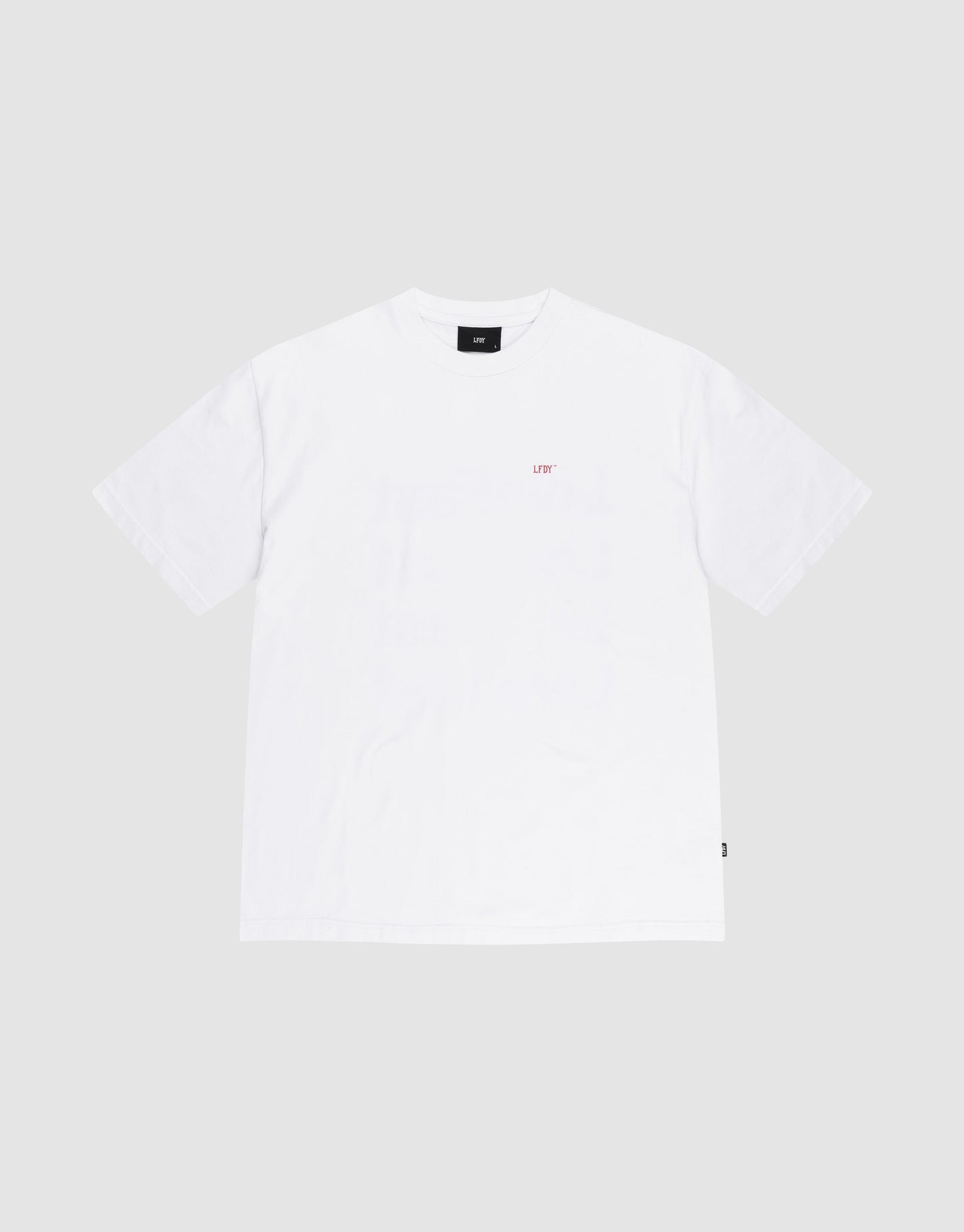 The Basic Evidence Tee by LIVE FAST DIE YOUNG is a plain white short-sleeve cotton T-shirt in a comfortable oversize fit, featuring a small, subtle logo or text on the left chest, shown against a light grey background.