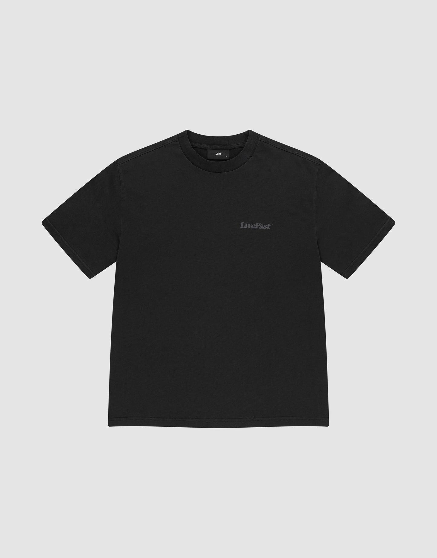 The LIVE FAST DIE YOUNG Basic 280 Tee is a plain black, short-sleeve t-shirt made from 100% Baumwolle, featuring a small LiveFast logo on the left chest and shown on a light gray background.