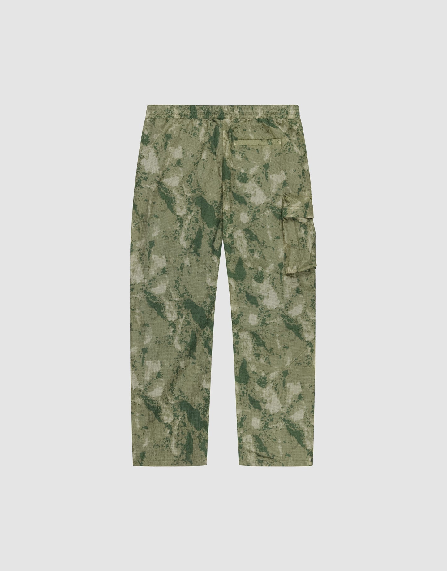 The LIVE FAST DIE YOUNG Live Fast Nylon Pants feature a relaxed oversize fit, side pockets, a utility cargo pocket, and an abstract green nylon camo design. Shown on a plain white background.
