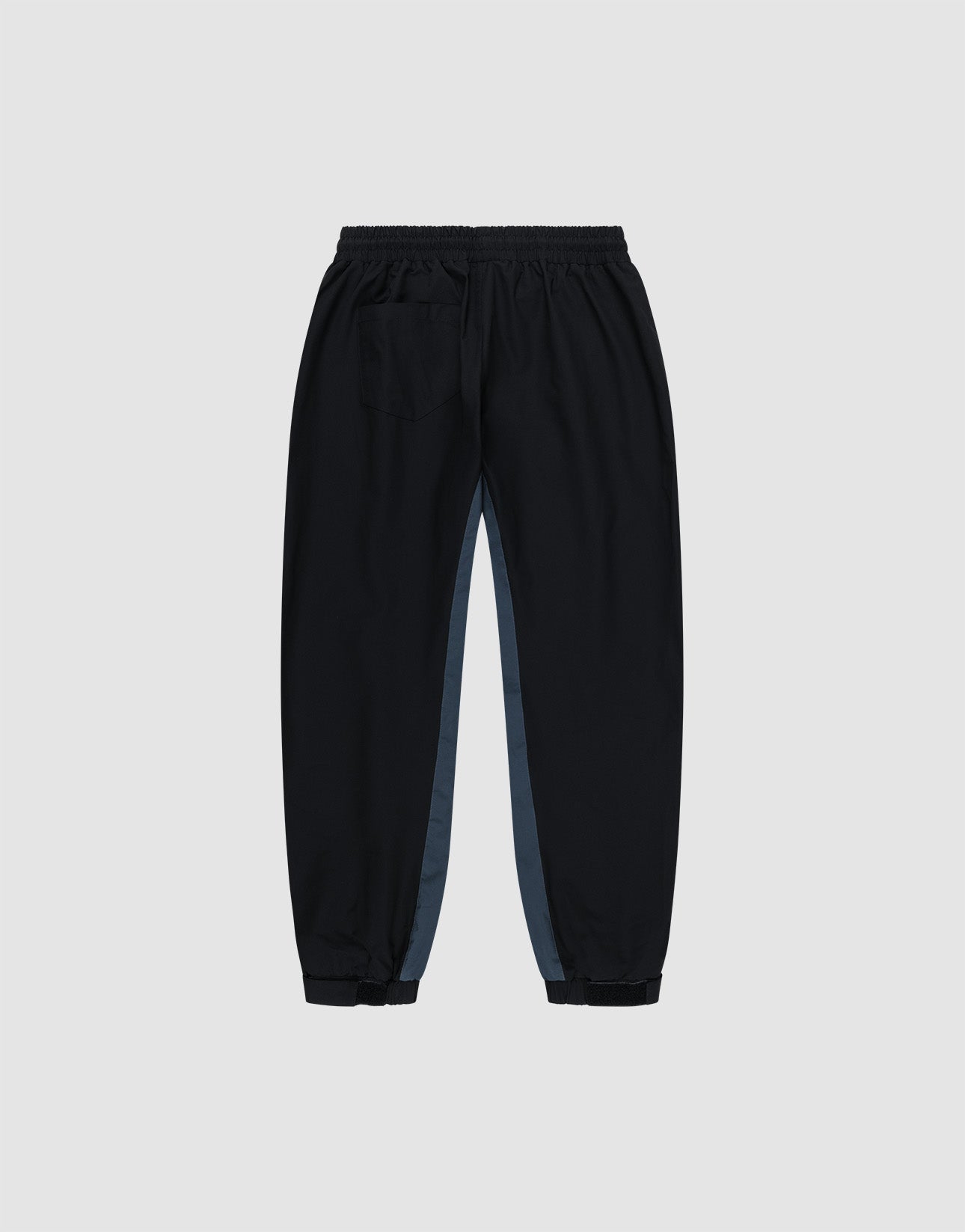 The LIVE FAST DIE YOUNG Basic Shell Pants are black jogger-style trousers with an oversize fit, Elastikbund, a right back pocket, and grey side panels, shown on a light grey background.