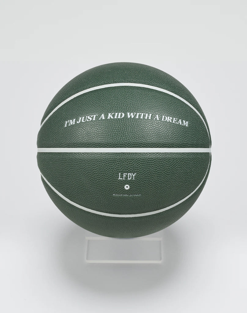 The Live Fast Basketball by LIVE FAST DIE YOUNG is a dark green ball with white lines and a grippy hygroscopic PU surface. IM JUST A KID WITH A DREAM and “LFDY” are printed on it. Comes on a clear stand. For indoor and outdoor use.