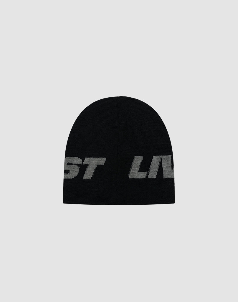The Live Fast Jacquard Beanie by LIVE FAST DIE YOUNG is a black polyacryl hat featuring large, bold gray jacquard logo lettering, partially visible against a plain light gray background. LF2504-17542.