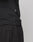 Close-up of a person in a black LFDY Slim Tee by LIVE FAST DIE YOUNG and black sweatpants. The side hem shows a small Flag-Label with white MOVT text. Made from soft Baumwolle, the tee is set against a plain light gray background.
