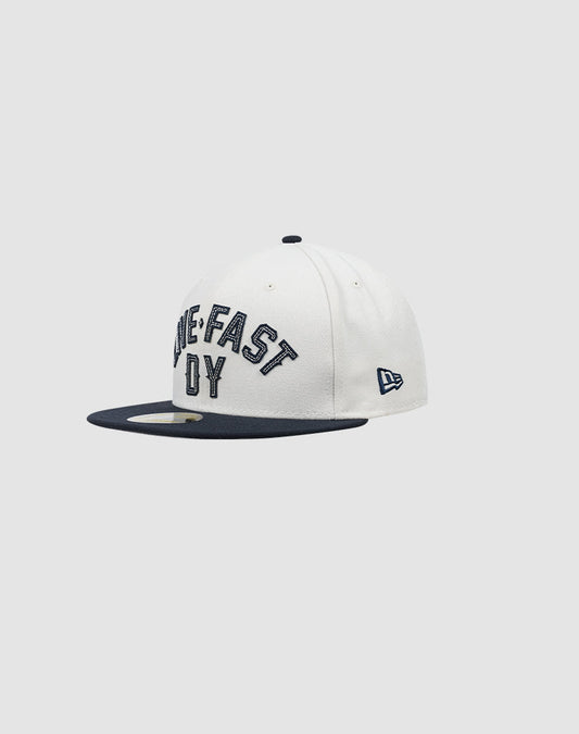The LFDY X NEW ERA 59FIFTY by LIVE FAST DIE YOUNG is a white fitted cap with a dark navy brim, bold LIVE FAST embroidery, partially hidden letters, and a side logo. Displayed on a plain gray background. Größentabelle available.