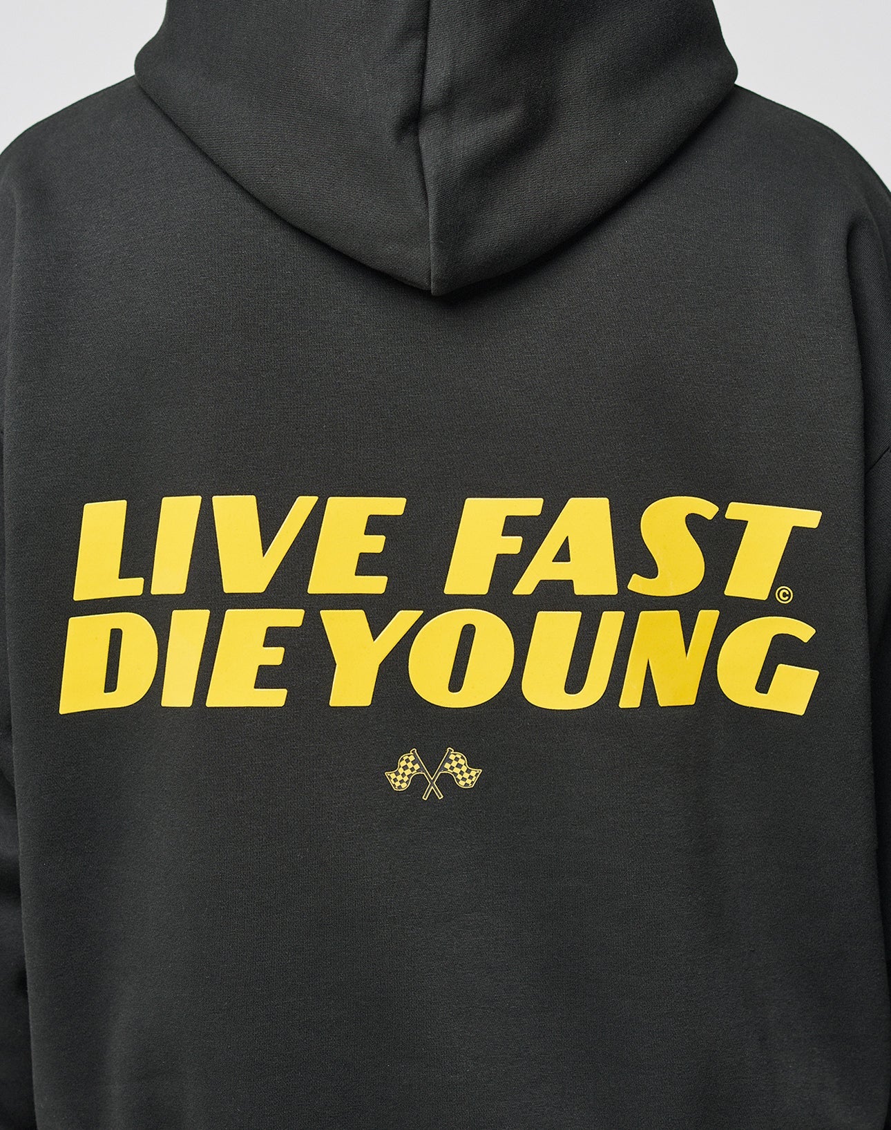 The LFDY Drift Hooded by LIVE FAST DIE YOUNG is a black Baumwolle hoodie with a doppellagige Kapuze, bold yellow LIVE FAST DIE YOUNG text and crossed checkered flags on the back. Oversize Fit for a relaxed style.