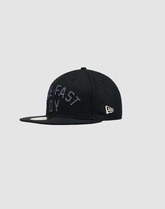 The LFDY X NEW ERA 59FIFTY by LIVE FAST DIE YOUNG is a black fitted cap with a flat brim, raised embroidered front text, and the New Era logo on the side. Shown on a plain light gray background. Größentabelle available for sizing.