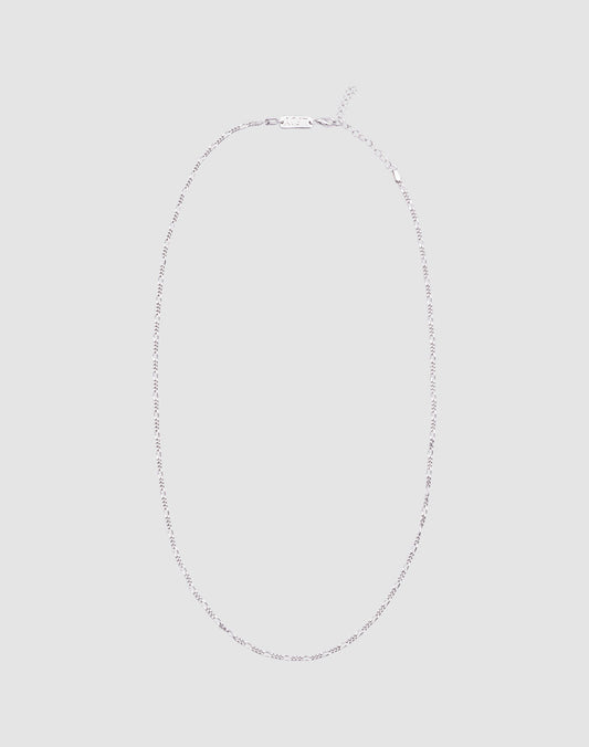 The LIVE FAST DIE YOUNG Basic Figaro Chain is a delicate 925 Sterling Silber necklace with a simple clasp, shown in an oval on a light gray background. Die Kettenlänge ist verstellbar für deine perfekte Passform.| plain