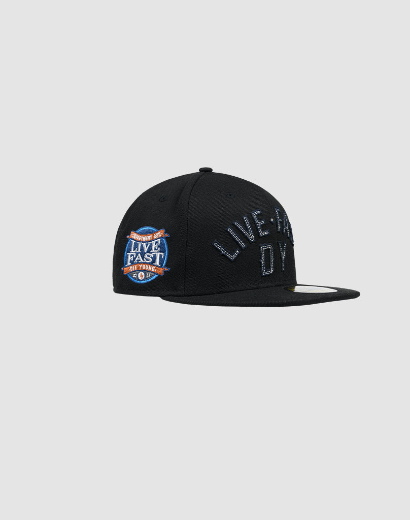The LFDY X NEW ERA 59FIFTY by LIVE FAST DIE YOUNG is a black fitted snapback with a flat brim, LIVE FAST embroidered front, and colorful side patch, shown on a light gray background. See our Größentabelle for your perfect fit.