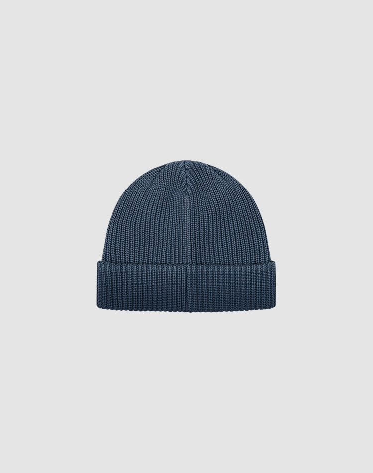 The LIVE FAST DIE YOUNG Double Rib Knit Beanie in dark blue features a folded brim and voluminous look, showcased against a plain light gray background.