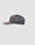 Side view of the gray LFDY Rivet Trucker cap by LIVE FAST DIE YOUNG, with a mesh back, solid front panel, slightly curved brim, and a black Flag-Label tag on the mesh. Set against a plain light gray background.
