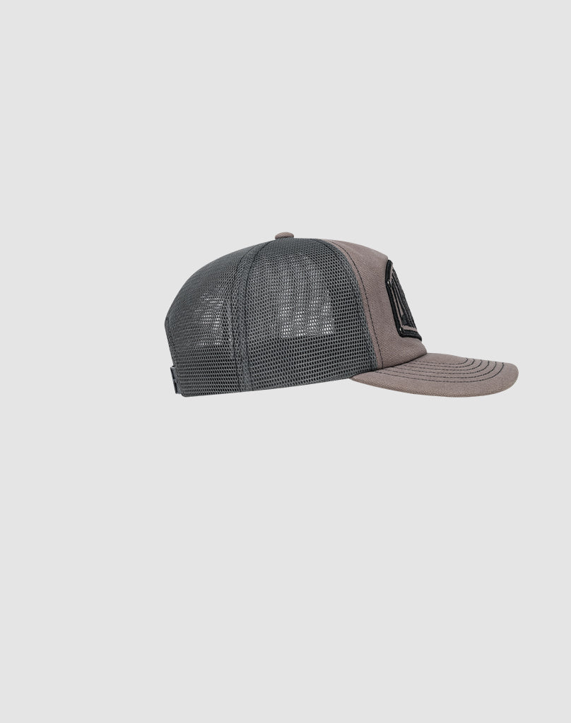 The LFDY Rivet Trucker by LIVE FAST DIE YOUNG is a gray and black cap with a curved brim, mesh back panels, and a solid front featuring a subtle Logo-Stick detail, shown in side profile on a plain light gray background.