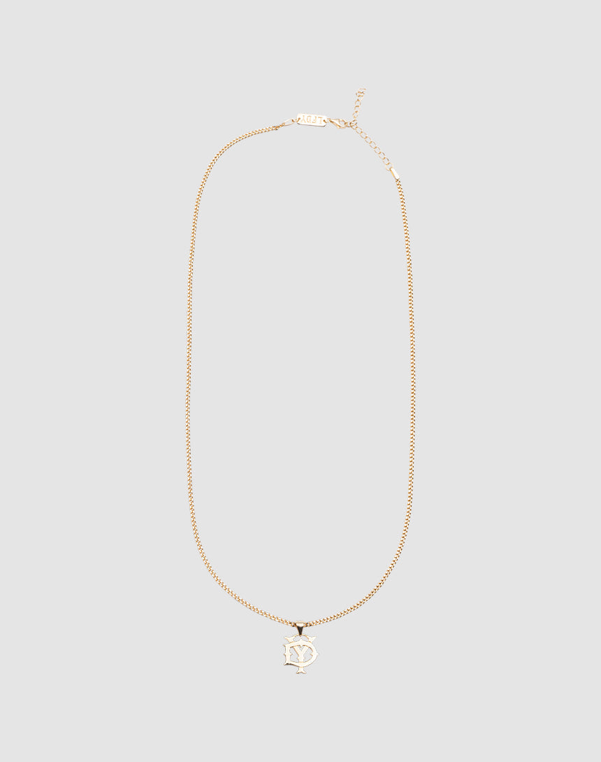 The DY Blank Chain by LIVE FAST DIE YOUNG is a gold necklace with a pendant of overlapping N and Y letters in a stylized font, made from 925 Vergoldet Sterling Silber, shown on a plain light gray background.