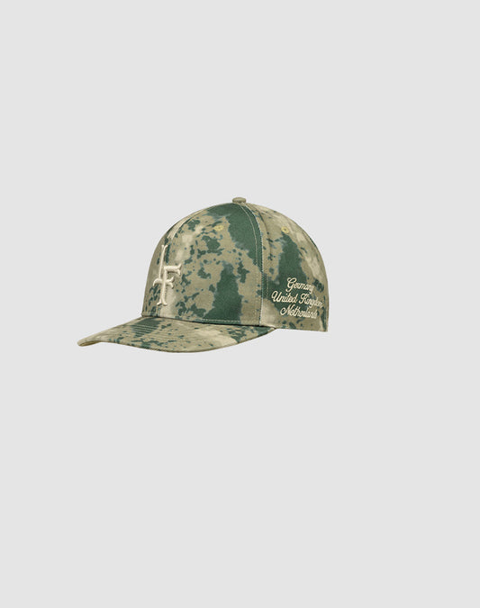 The LF Snapback by LIVE FAST DIE YOUNG is a green camouflage cap made from 100% Baumwolle, featuring an abstract light design and cursive Grateful United Times Maverick Logo-Stick embroidery on the side.