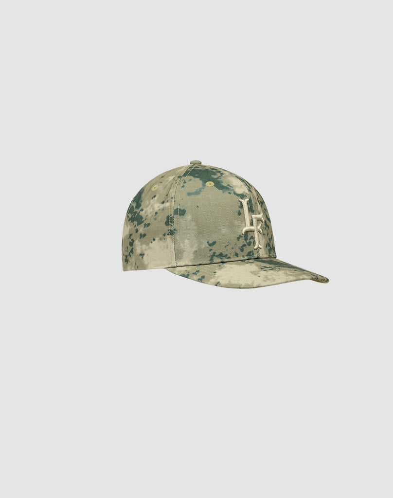 The LF Snapback by LIVE FAST DIE YOUNG is a camouflage cap crafted from 100% Baumwolle, featuring a white embroidered logo cross on the front, shown against a plain light gray background. Model: LF2506-18254.
