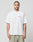 A man faces forward in a white oversized Hit and Run Tee by LIVE FAST DIE YOUNG, made from 100% Baumwolle, with short sleeves and beige pants. The tee features a small red LIVE FAST graphic on the left chest, set against a plain light gray background.