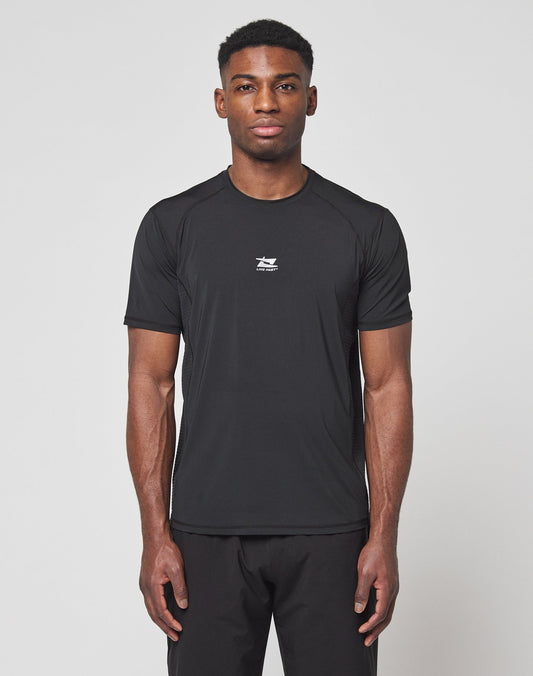 A man faces forward against a white background, wearing the LIVE FAST DIE YOUNG Live Fast Performance Tee in black, featuring a slim fit, short sleeves, small white chest logo, and comfortable Nylon Spandex material with matching black pants. | model