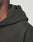 Close-up of a person wearing the LFDY Sharkhunter Hooded by LIVE FAST DIE YOUNG in an Oversize Fit, showing the neck, shoulder, and hood against a plain background. The soft Baumwolle fabric features subtle Bündchen details.