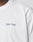 A close-up shows part of a persons shoulder and neck wearing the LIVE FAST DIE YOUNG Live Fast Paris Tee, a white 100% cotton T-shirt featuring “Livé Fast” in small blue and pink text on the left chest.