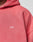 Close-up of a person wearing the LIVE FAST DIE YOUNG Basic Hooded Zip in pink, featuring a small white LFDY™ logo print on the front and showcasing the fabric’s subtle fade effect. Only part of the hoodie and their neck and chin are visible.