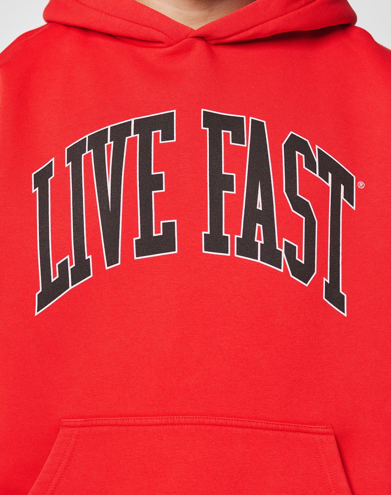 A close-up of the LIVE FAST DIE YOUNG Live Fast College Hooded, an Oversize Fit red hoodie with bold, black arched LIVE FAST lettering on the chest, made from soft Baumwolle and polyester for comfort and style.