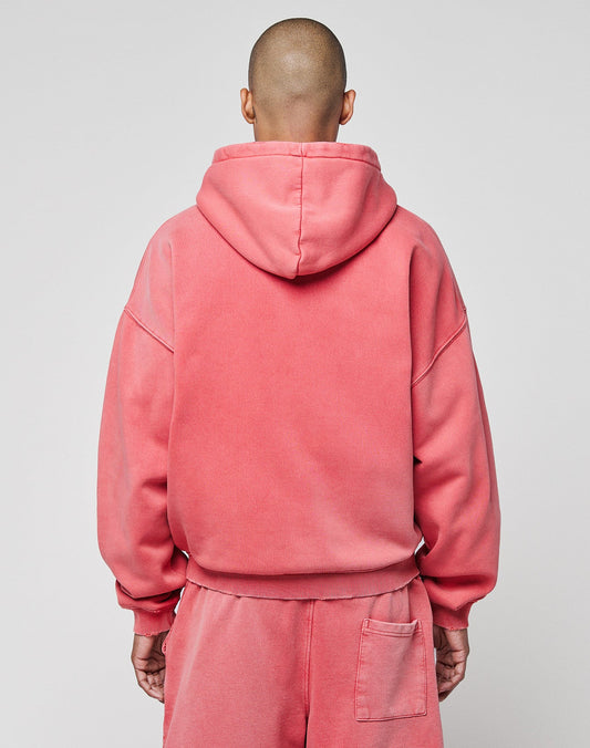 A person with a shaved head, seen from behind, wears a matching pink LIVE FAST DIE YOUNG Basic Hooded Zip and sweatpants with a subtle fade effect and back pocket. The hood is up, set against a plain light gray background.