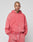 A person with tattoos on their head and neck models the LIVE FAST DIE YOUNG Basic Hooded Zip, a faded red hoodie with logo print and matching drawstring pants, standing against a plain light gray background, facing the camera.