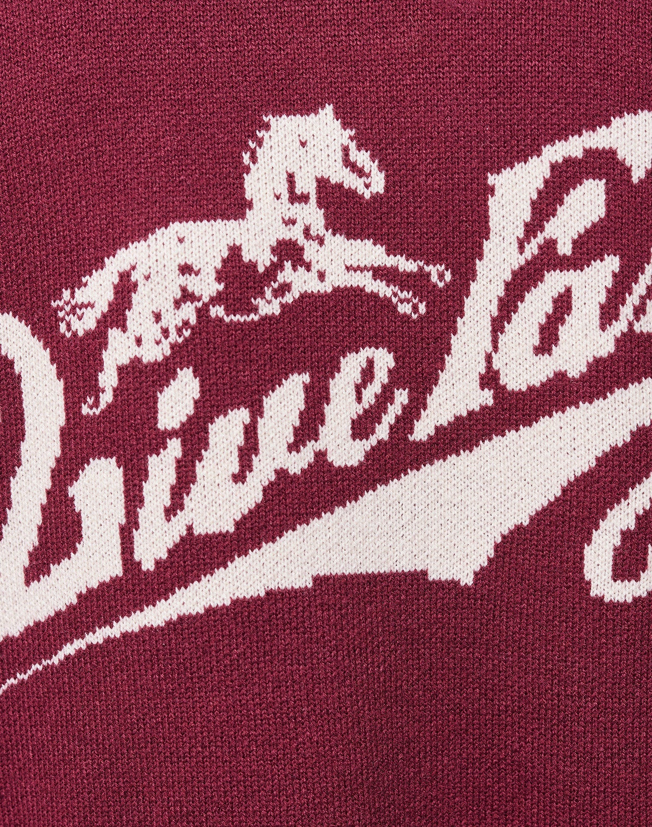 Close-up of the Boxy Knit Zip Jacket by LIVE FAST DIE YOUNG, featuring maroon and cream sections. Maroon fabric displays white embroidered "Live Fast Co." text near the chest in a stylish logo-knit detail.