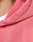 Close-up of a person wearing the Basic Hooded Zip by LIVE FAST DIE YOUNG in pink with individueller Sprayeffekt, highlighting the hood, shoulder stitching, and fabric texture. Part of the neck and a white shirt are also visible.