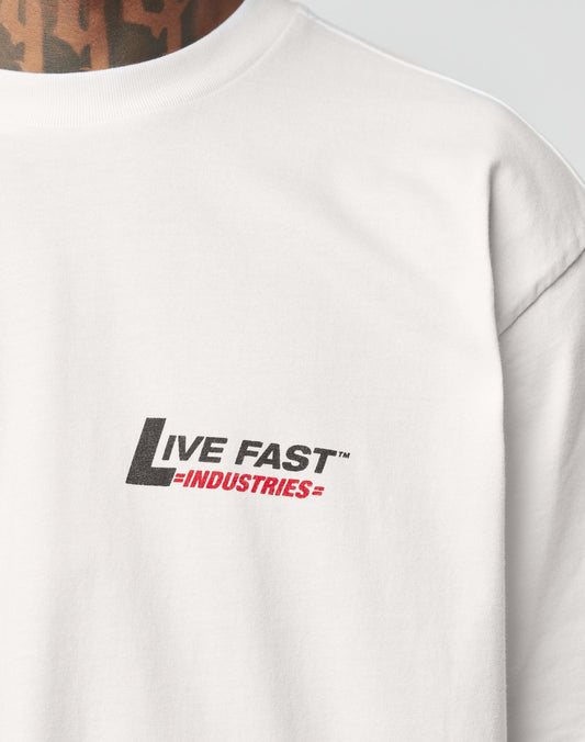 Close-up of the white LFDY Industries Tee by LIVE FAST DIE YOUNG, featuring black and red chest print. Shows its Oversize Fit with part of a tattooed neck visible above the collar.