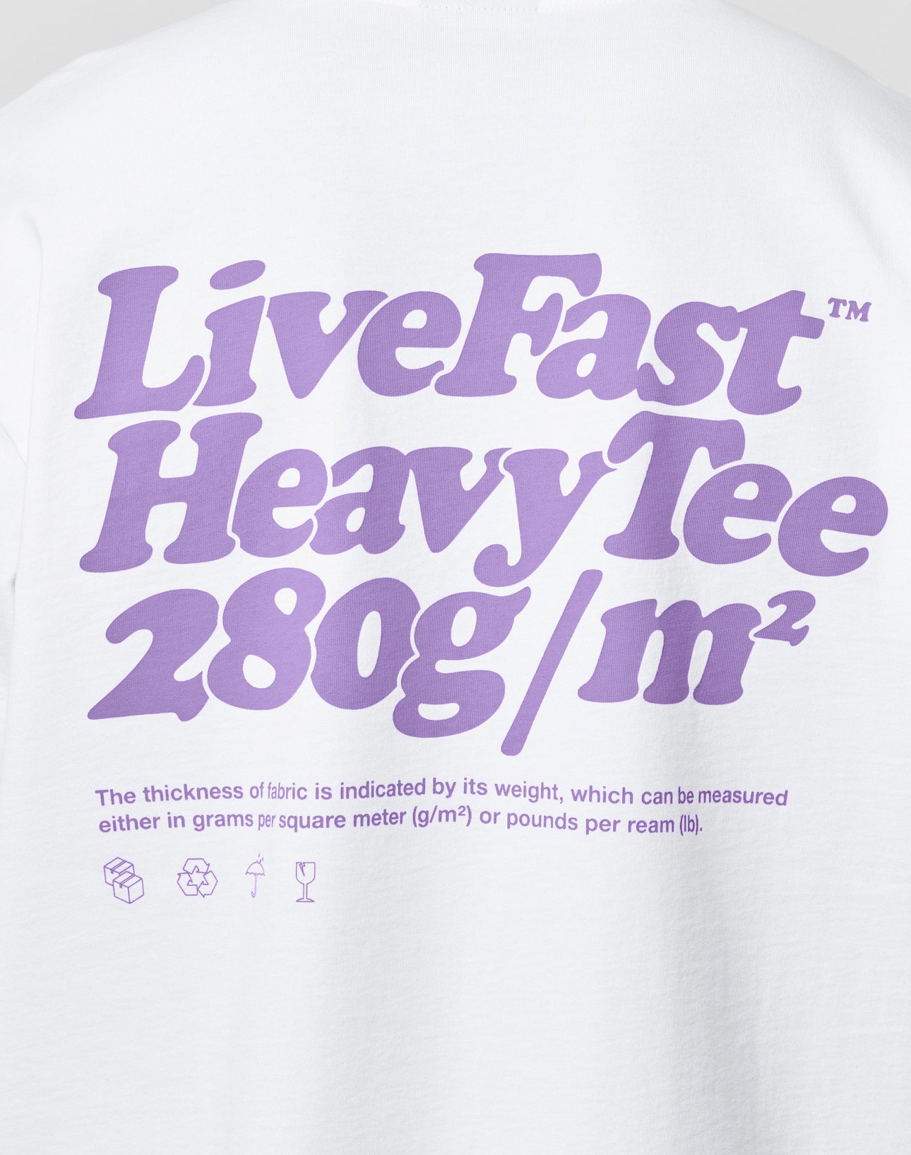White shirt featuring bold purple LIVE FAST DIE YOUNG Basic 280 Tee text. Made from 100% Baumwolle, 280g/m² in oversize fit with front and back print, fabric info in smaller text, and icons below for added flair.